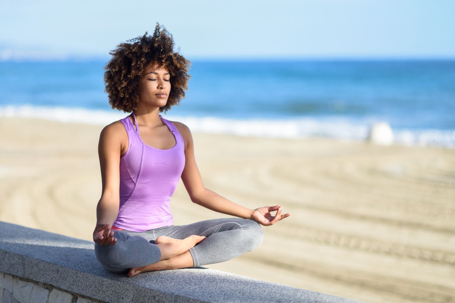 Person meditating on the beach