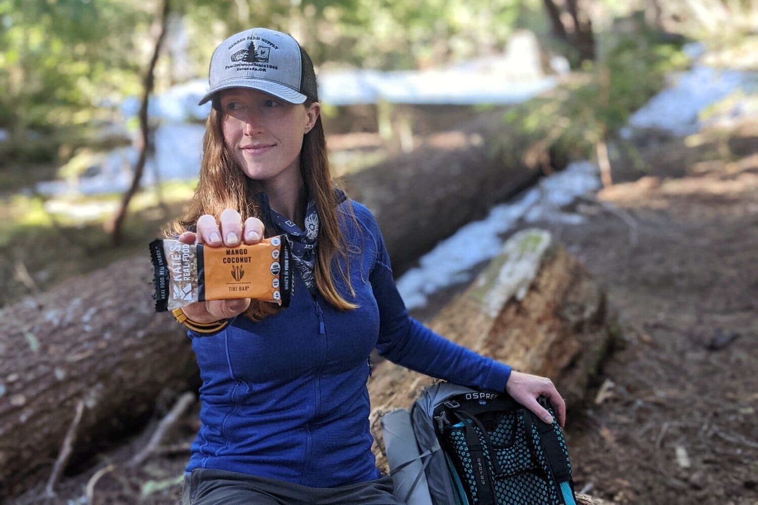 Woman outdoors holding up an energy bar