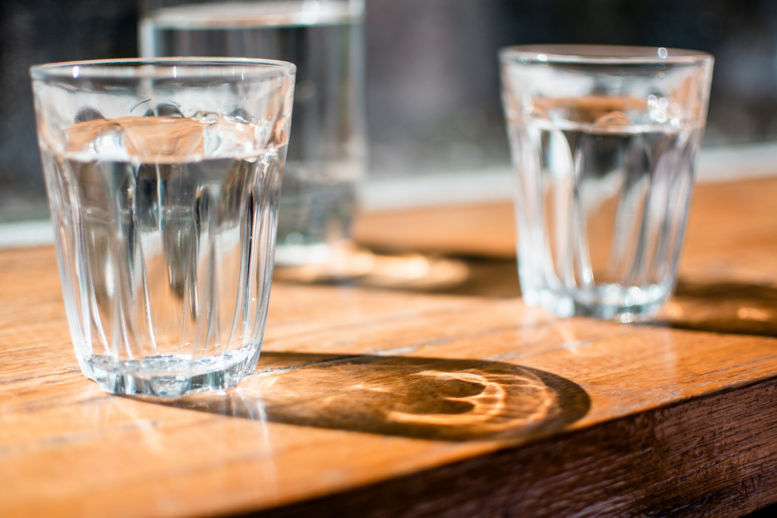 Two glasses of water on a table. 