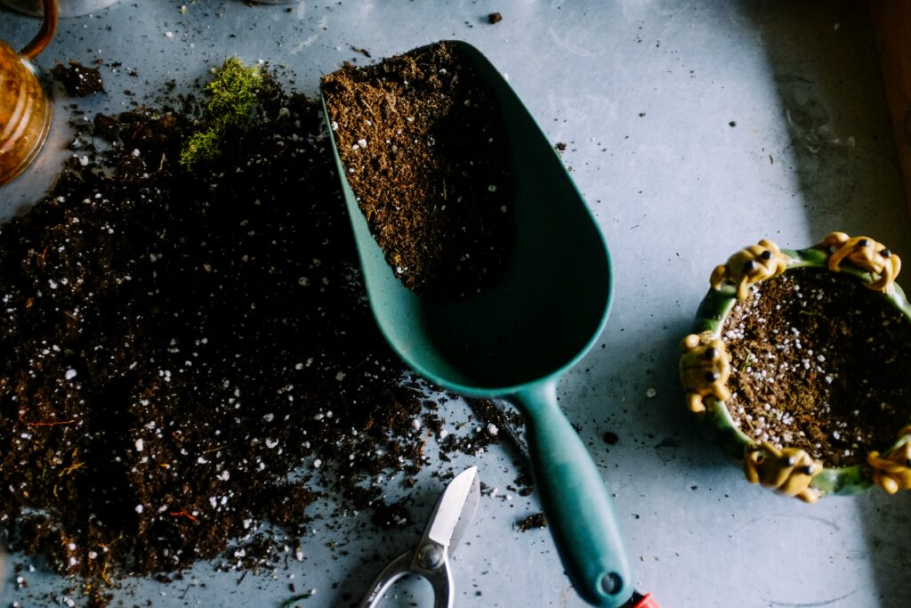 A shovel filled with soil from a garden. 