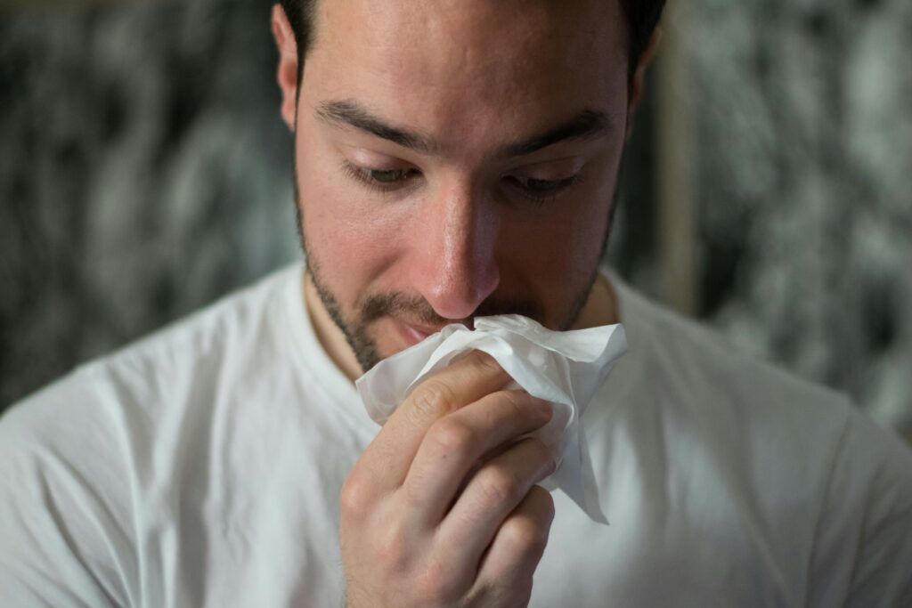 man sneezing from allergies