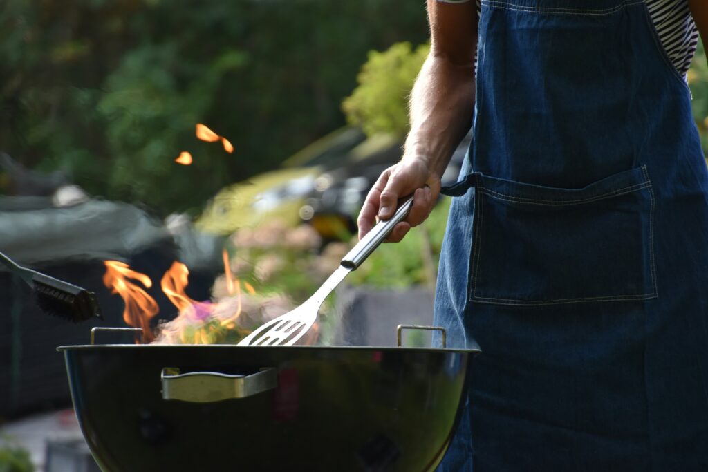 man at grill with flames